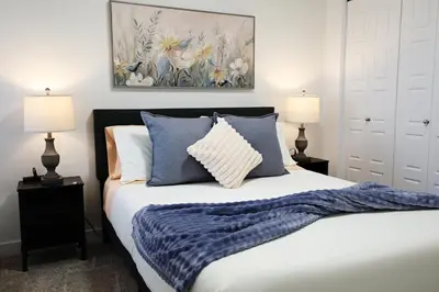 a bedroom with a bed with blue and white pillows at Kinglet 4BR Getaway AC Garage Near WEM DisneyPlus in Edmonton