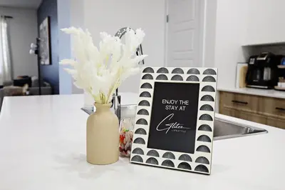 a vase with white flowers and a sign on a counter at Kinglet 4BR Getaway AC Garage Near WEM DisneyPlus in Edmonton
