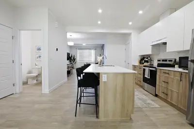 a kitchen with a island in the middle of a room at Kinglet 4BR Getaway AC Garage Near WEM DisneyPlus in Edmonton