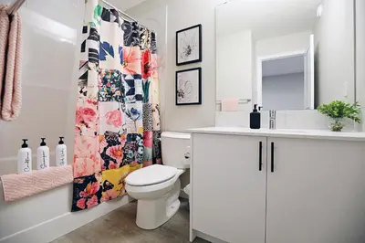a bathroom with a toilet and a shower curtain at Edgemont Getaway King Bed Garage WEM And DisneyPlus in Edmonton