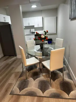 a dining room with a glass table and chairs at Bedroom in the basement Upland 2 in Edmonton