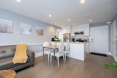 a kitchen and living room with a table and chairs at Brand New Stylish 2 bedrooms Suite in Shaughnessy in Vancouver