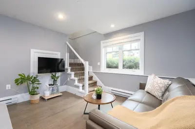 a living room with a couch and a tv at Brand New Stylish 2 bedrooms Suite in Shaughnessy in Vancouver