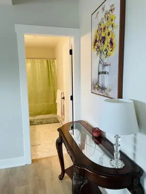 a room with a glass table and a vase of flowers at Casa Del Mar-A family Suite in Victoria in Langford