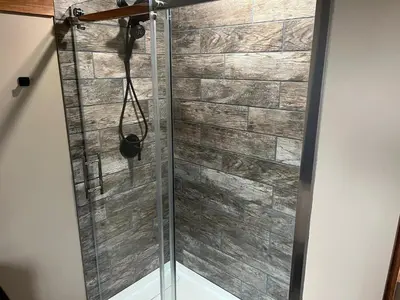 a shower with a glass door in a bathroom at Ellison Funny Farm in Barrière