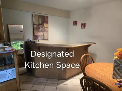 a kitchen with a table and a kitchen space at Self Check-In Keyless Private Entry DBL Queen Suite in Mission City