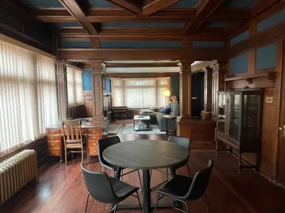 a person sitting in a room with a table and chairs at The Algonquin Residence in Prince Rupert