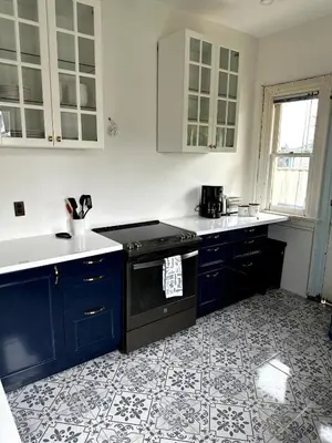 a kitchen with blue cabinets and a black stove at The Algonquin Residence in Prince Rupert