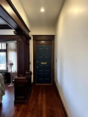 a hallway with a blue door and wooden floors at The Algonquin Residence in Prince Rupert
