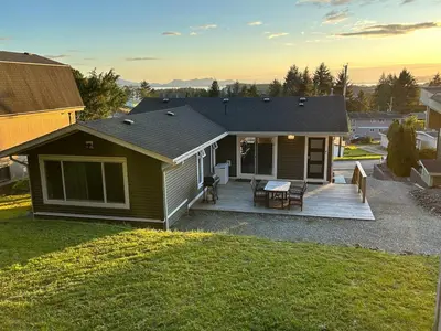 a house with a deck with a table and chairs at 3 BR Serene Forest Sanctuary in Port Edward