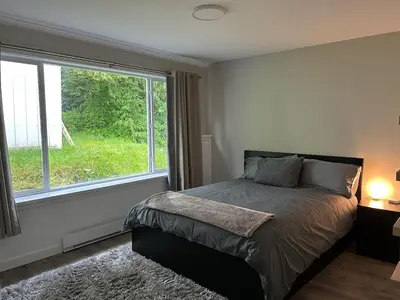 a bedroom with a bed and a large window at 3 BR Serene Forest Sanctuary in Port Edward