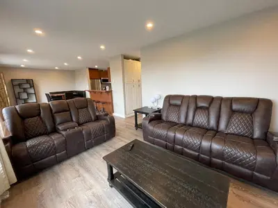 a living room with two brown leather couches and a table at 3 BR Serene Forest Sanctuary in Port Edward
