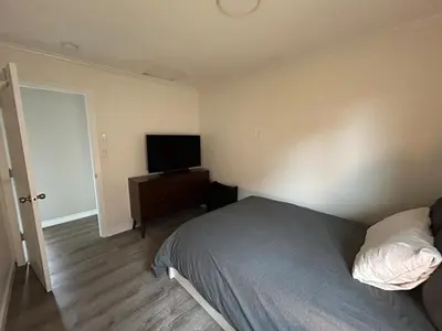 a bedroom with a bed and a flat screen tv at 3 BR Serene Forest Sanctuary in Port Edward