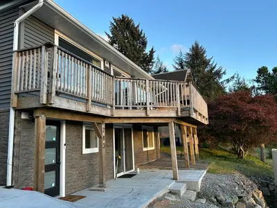 a house with a deck on top of it at 2BR Seaside Haven Retreat