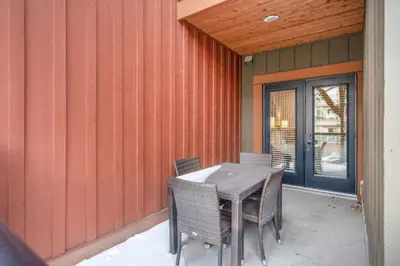 a table and chairs on the outside of a house at Mountain Escape 2BR Hot tub and Pool Near Banff in Canmore
