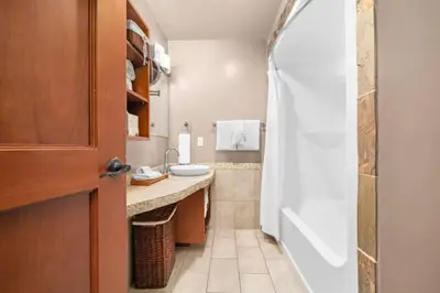 a bathroom with a shower and a sink at Mountain Escape 2BR Hot tub and Pool Near Banff in Canmore