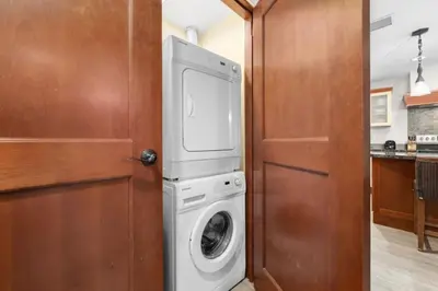 a washer and dryer in a kitchen next to a door at Mountain Escape 2BR Hot tub and Pool Near Banff in Canmore