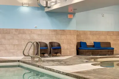 a swimming pool with three chairs and a swimming pool at Mountain Escape 2BR Hot tub and Pool Near Banff in Canmore
