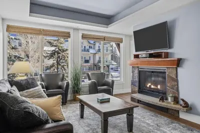 a living room with a fireplace and a tv at Mountain Escape 2BR Hot tub and Pool Near Banff in Canmore