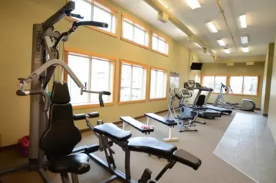 a gym with a bunch of exercise bikes in a room at Spacious Getaway near Banff with Heated Pool in Canmore