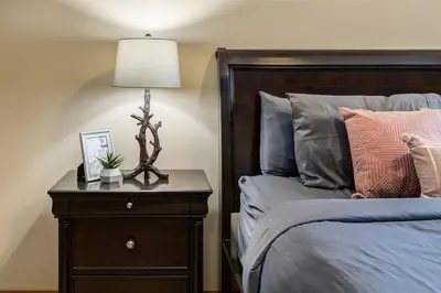 a bedroom with a bed and a lamp on a night stand at 3BR Rockies Condo Heated Pool and Hot Tub in Canmore