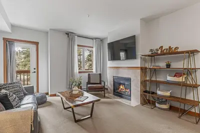 a living room with a couch and a fireplace at Chic 1BR City Nest Heated Parking and Hot Tub and Pool in Canmore