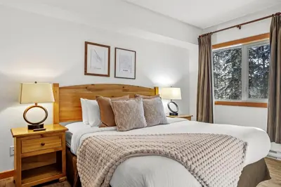a bedroom with a large bed and two lamps at 3BR Family Friendly Getaway Pool and Hot Tub in Canmore