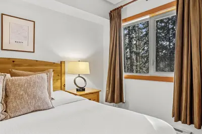 a bedroom with a white bed and a window at 3BR Family Friendly Getaway Pool and Hot Tub in Canmore