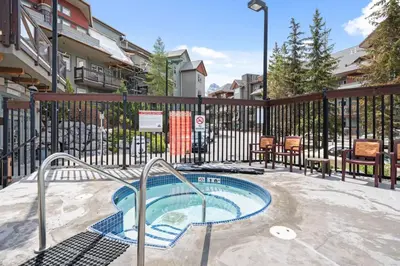 a swimming pool in a courtyard with a fence at 3BR Family Friendly Getaway Pool and Hot Tub in Canmore