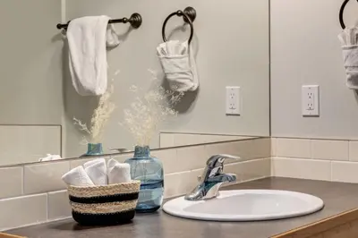 a bathroom counter with a sink and a mirror at Lovely 2BR Canmore Condo w Heated Pool and Hot Tub in Canmore