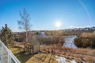 a tiny house on the side of a river at Bright & Spacious 5-BR & Ravine Views in Edgemont in Calgary
