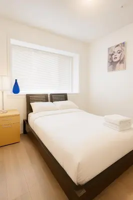 a bedroom with a large bed and a window at Sweet 2-bedrooms house in Vancouver in Vancouver