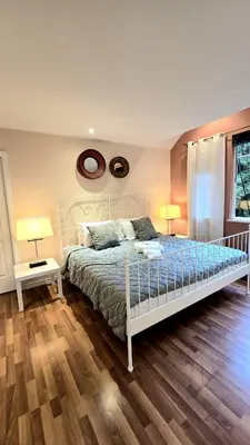 a bedroom with a white bed and two lamps at Spacious & Cozy House Near Lonsdale, Peaceful North Vancouver Stay in North Vancouver