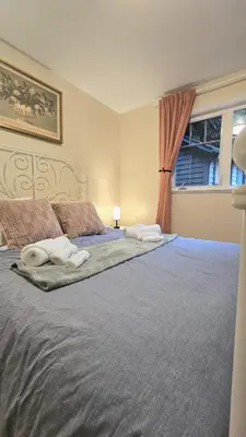 a bedroom with a large bed with a window at Spacious & Cozy House Near Lonsdale, Peaceful North Vancouver Stay in North Vancouver