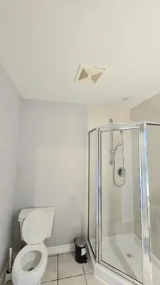 a bathroom with a toilet and a shower at Spacious & Cozy House Near Lonsdale, Peaceful North Vancouver Stay in North Vancouver