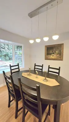 a dining room with a black table and chairs at Spacious & Cozy House Near Lonsdale, Peaceful North Vancouver Stay in North Vancouver