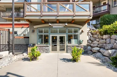 a front door of a building with a balcony at Sleeps 8 Loft with Pool Hot Tub Near Banff in Canmore
