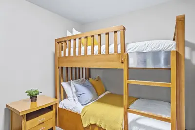 a wooden bunk bed with a desk and a night stand at Rockies Getaway 2BR with Patio Hot Tub and Gym in Dead Man's Flats