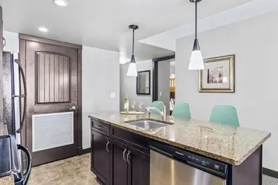 a kitchen with a sink and blue chairs at Rockies Getaway 2BR with Patio Hot Tub and Gym in Dead Man's Flats