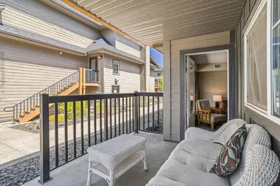 a porch with a couch and chairs on a balcony at Cozy Oasis 2BR with Hot Tub and Gym 10 Mins to DT in Dead Man's Flats