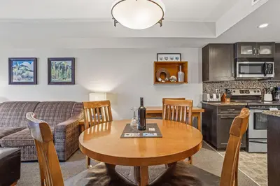 a kitchen and living room with a table and a couch at Cozy Oasis 2BR with Hot Tub and Gym 10 Mins to DT in Dead Man's Flats