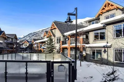 a tennis court in front of a house at Cozy Condo With Hot Tub Gym and Underground Parking in Dead Man's Flats