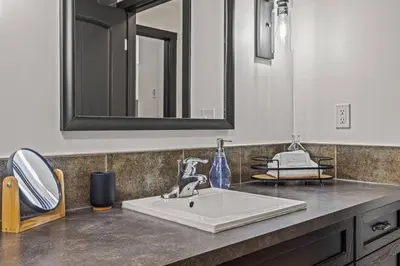 a bathroom counter with a sink and a mirror at Amazing 3BR Condo With Hot Tub Access and Mtn Views in Dead Man's Flats