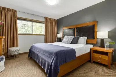 a bedroom with a large bed and a window at Lovely 3BR condo with Hot Tub at the Edge of Canmore in Dead Man's Flats