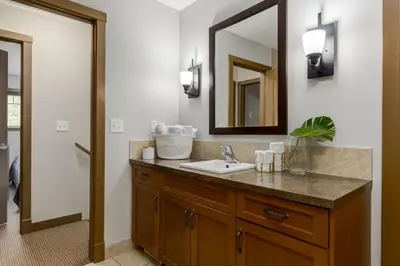 a bathroom with a sink and a mirror at Lovely 3BR condo with Hot Tub at the Edge of Canmore in Dead Man's Flats