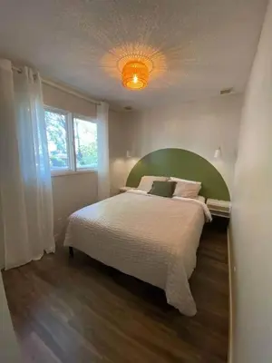 a bedroom with a large bed with a green headboard at New! Spacious Bright Home in GREAT Location in Red Deer