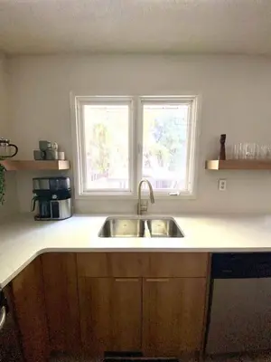 a kitchen counter with a sink and two windows at New! Spacious Bright Home in GREAT Location in Red Deer