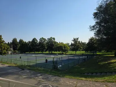 a tennis court in a park with people on it at Newly Renovated Cozy Guest House In Joyce-Collingwood in Vancouver