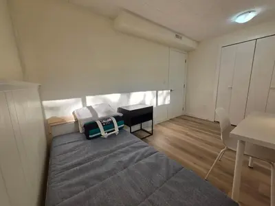 a bedroom with a bed and a table and a desk at Newly Renovated Cozy Guest House In Joyce-Collingwood in Vancouver