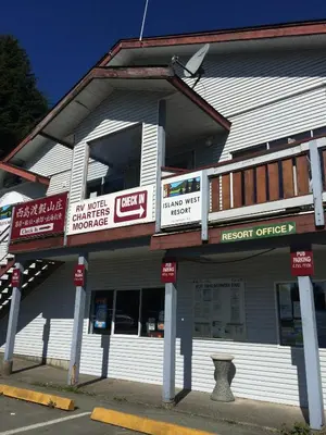a white building with signs on the side of it at Island West Resort-Motel in Ucluelet